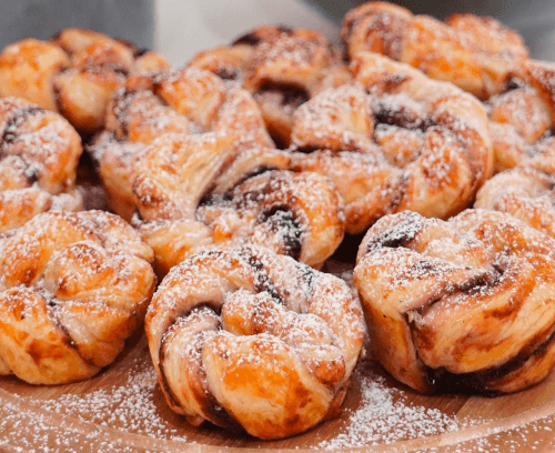 glutenfree blueberry swirls sprinkled with sugar presented on a wooden plate