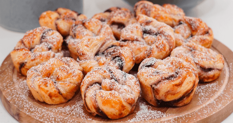 glutenfree blueberry swirls sprinkled with sugar presented on a wooden plate